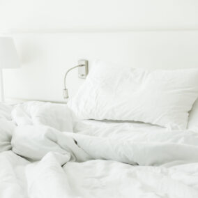 White pillow on rumpled bed decoration in bedroom interior
